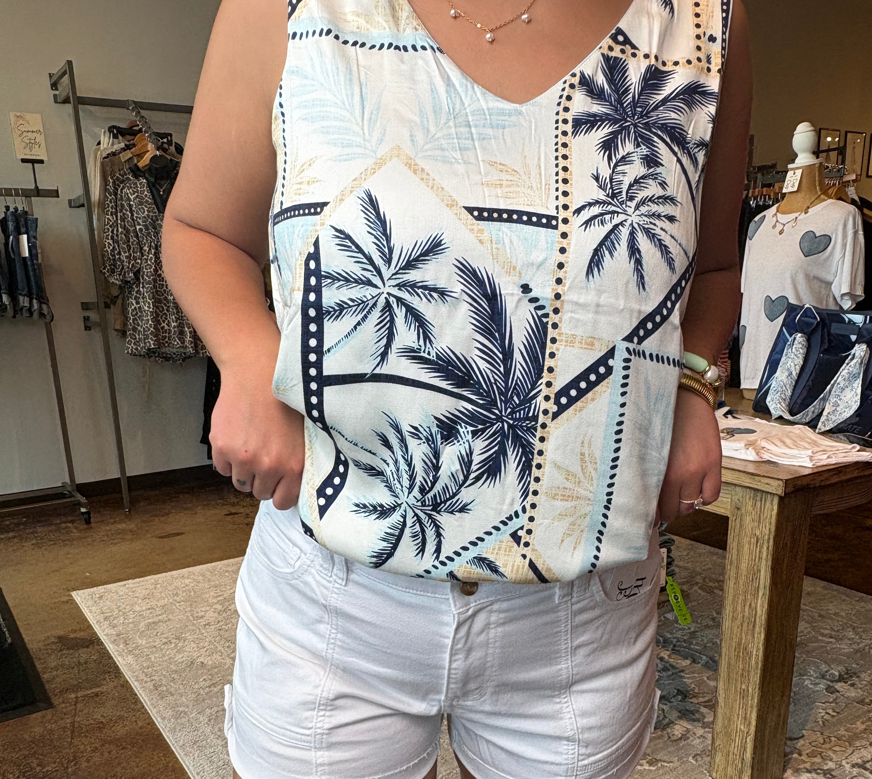Person wearing a patterned shirt and white shorts in an indoor setting