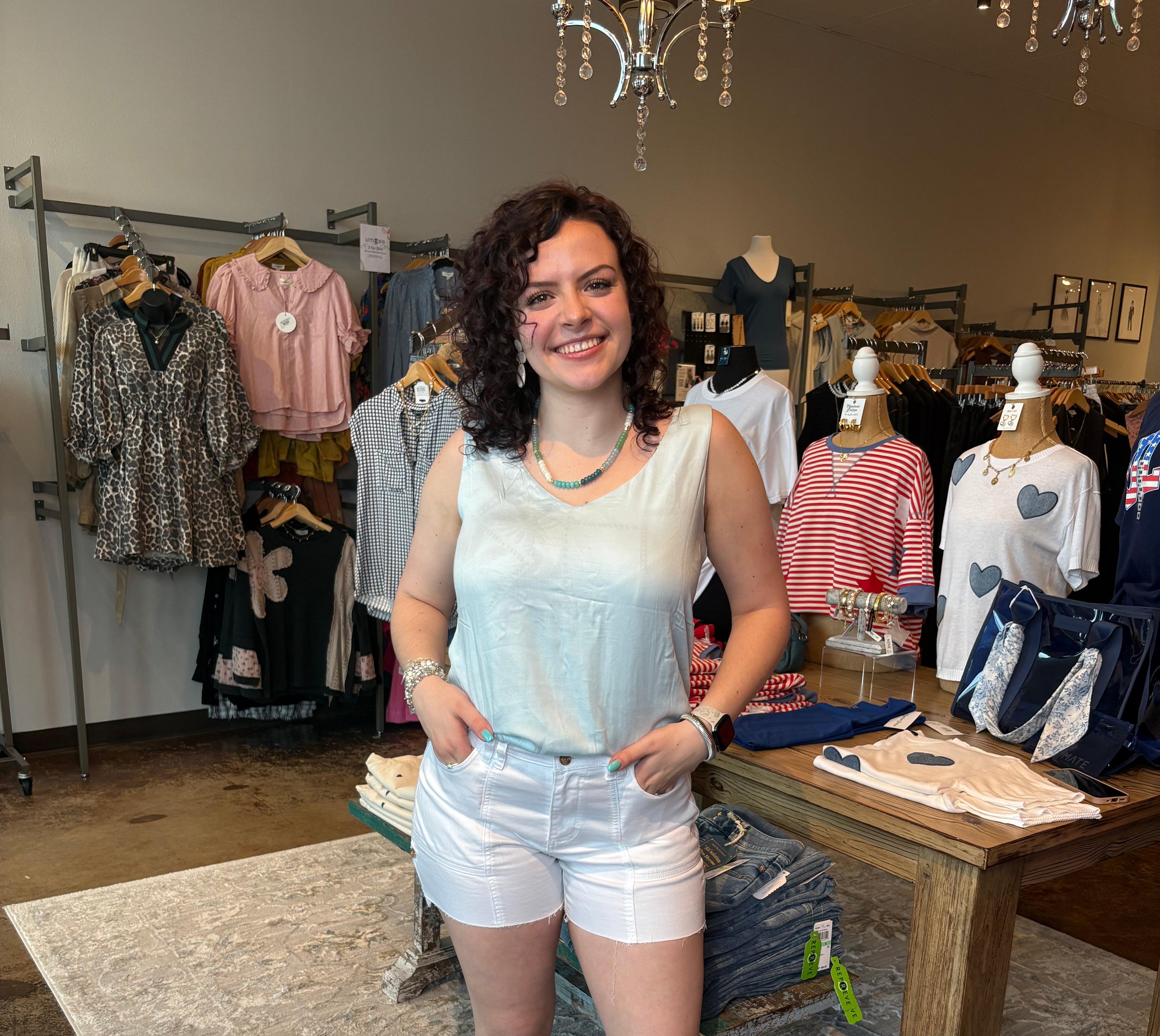 Woman wearing a sleeveless top with a palm tree pattern in a clothing store
