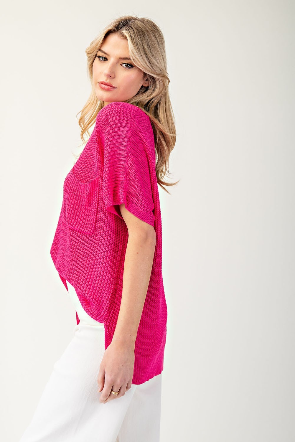 Woman wearing a bright pink sweater on a white background