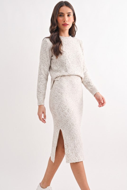 Model wearing oatmeal speckled knit midi pencil skirt, front view showing side slit
