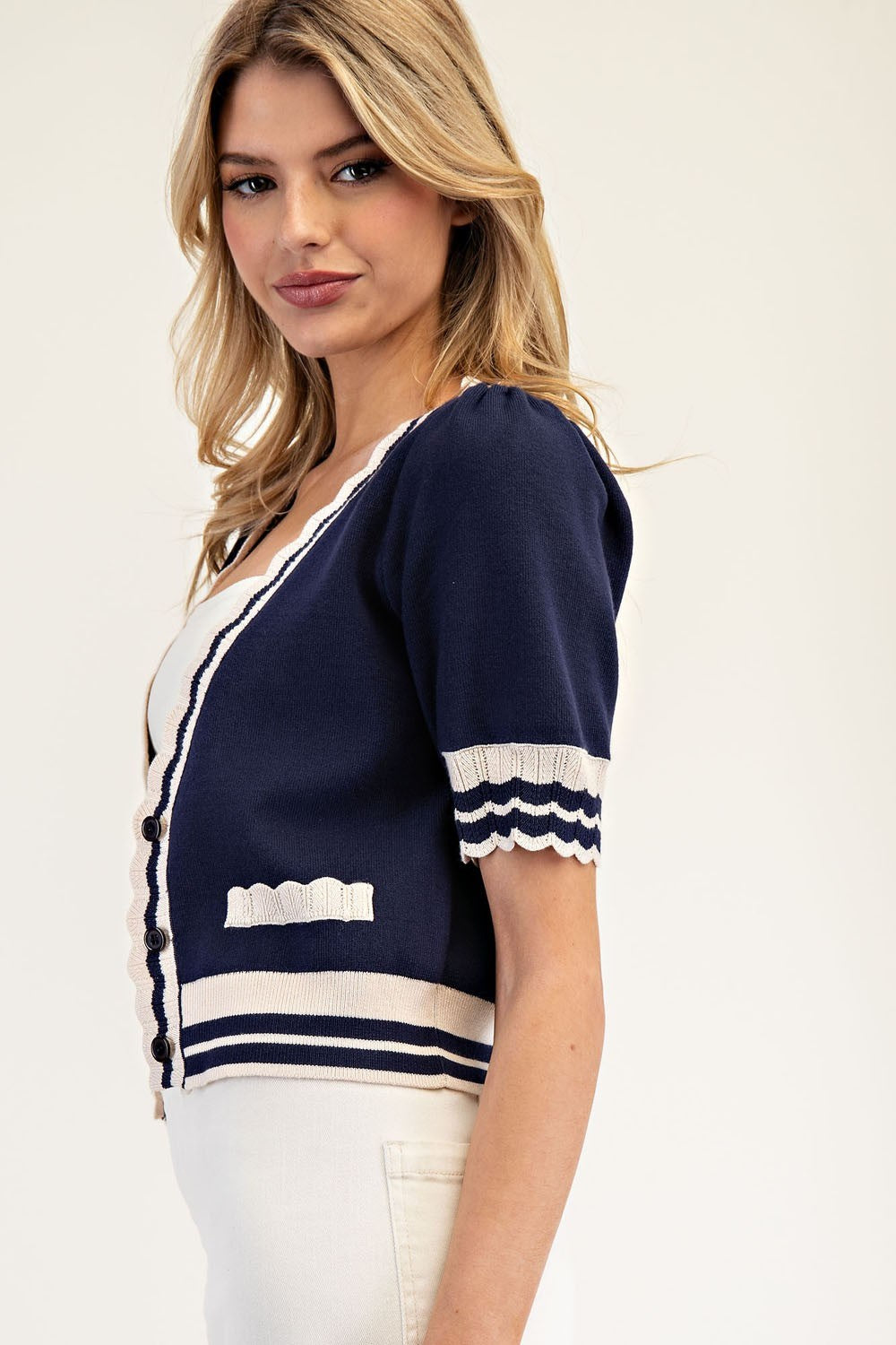 Woman wearing a navy and white striped top against a plain background