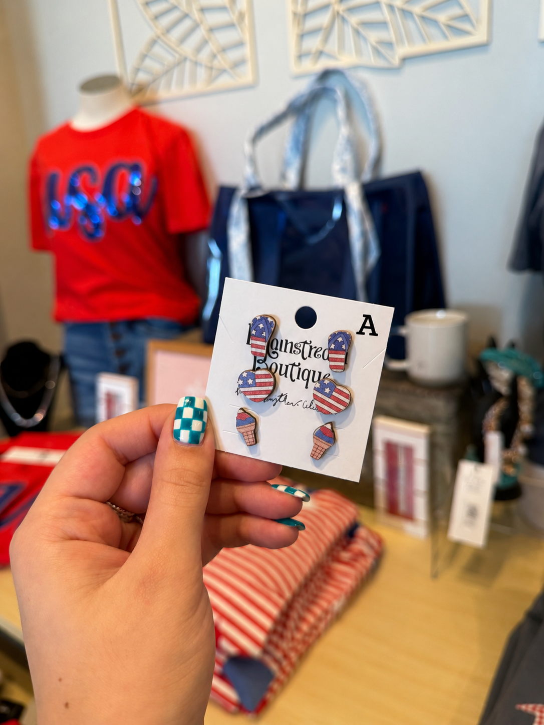 Hand holding a card with American flag-themed hair clips in a store setting