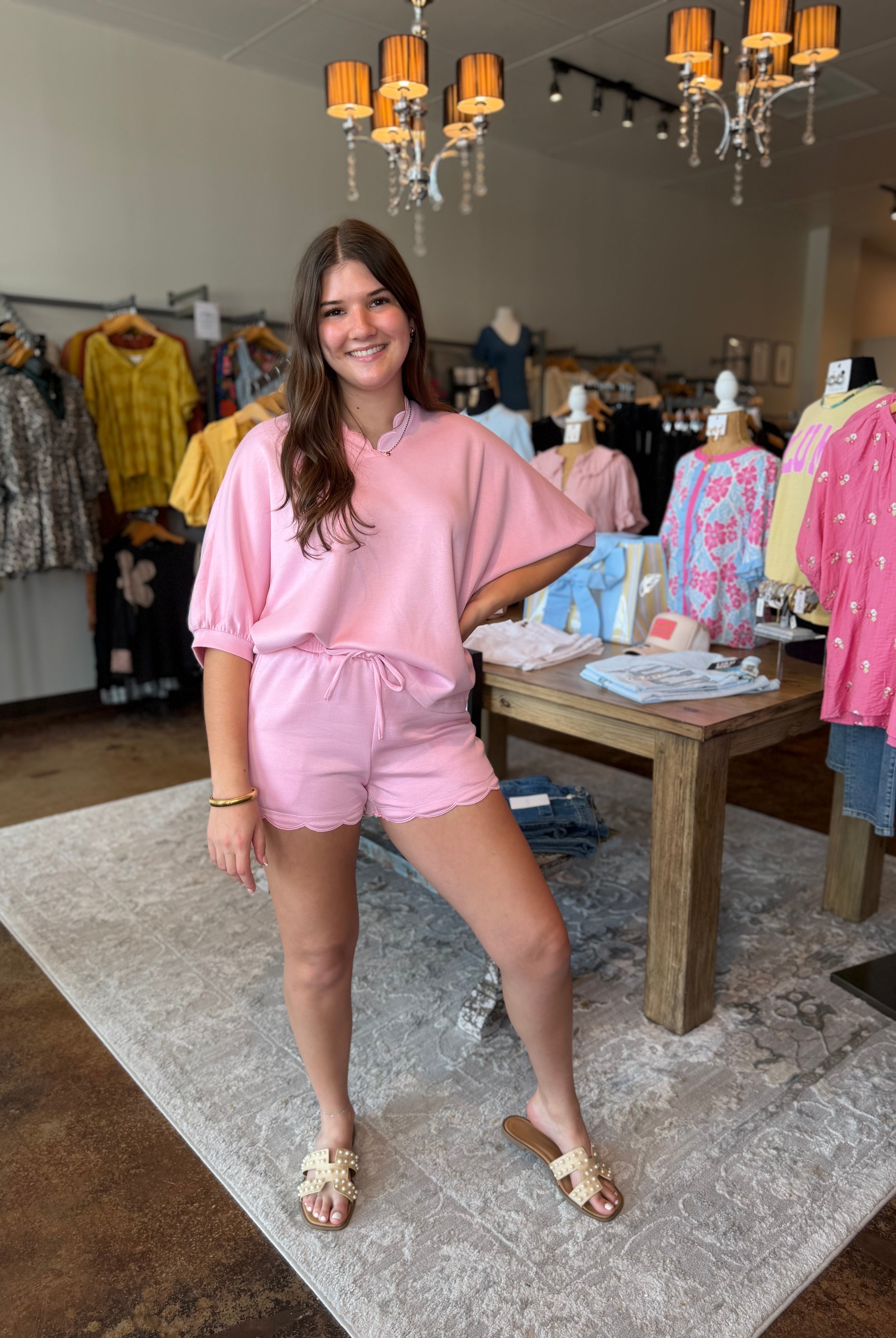 Woman in a pink outfit standing in a clothing store.