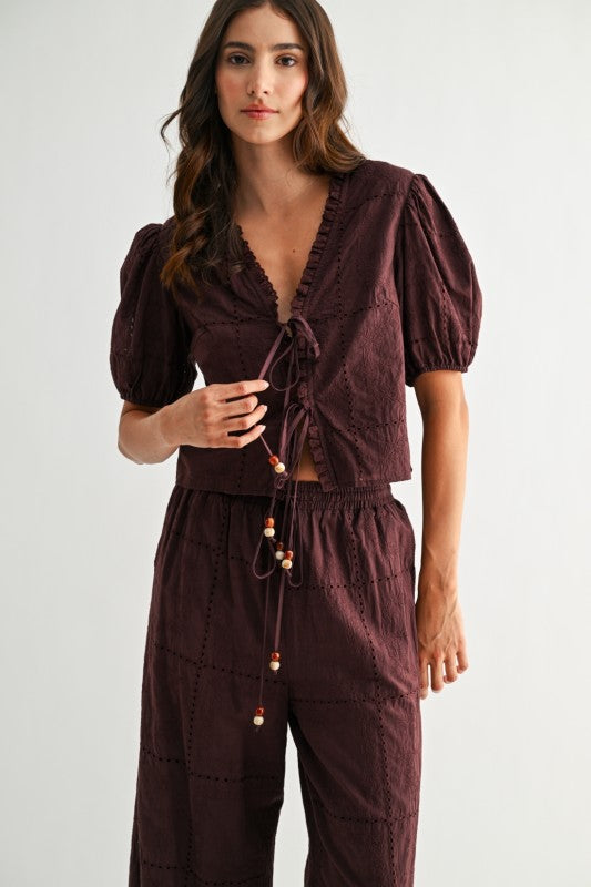 Model wearing brown embroidered puff sleeve tie-front top, full front view