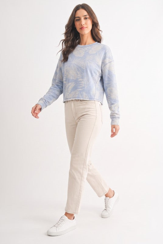 Model wearing dusty blue tropical print French terry crewneck sweatshirt, full length front view
