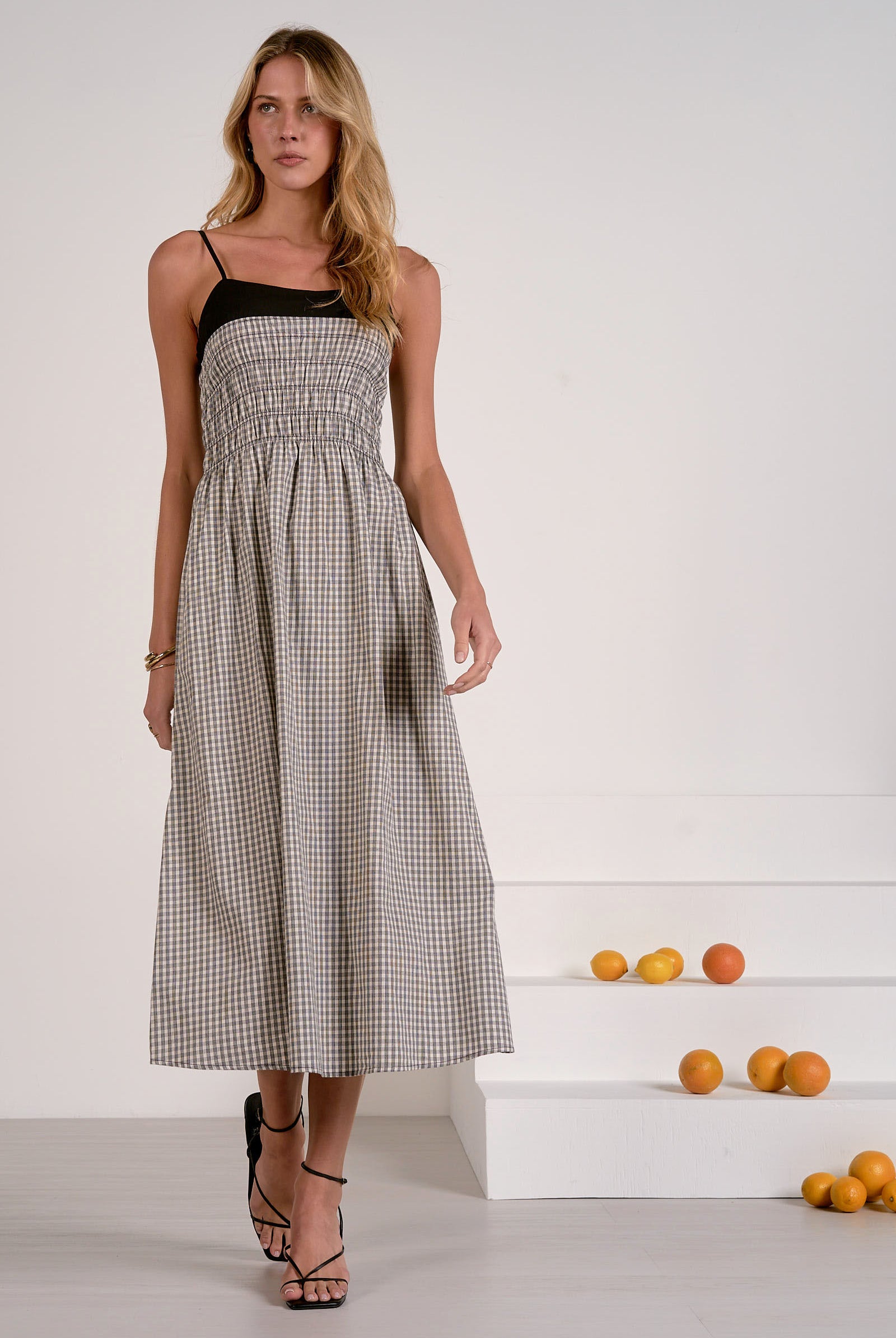 Woman wearing a black and white checkered dress with a plain background