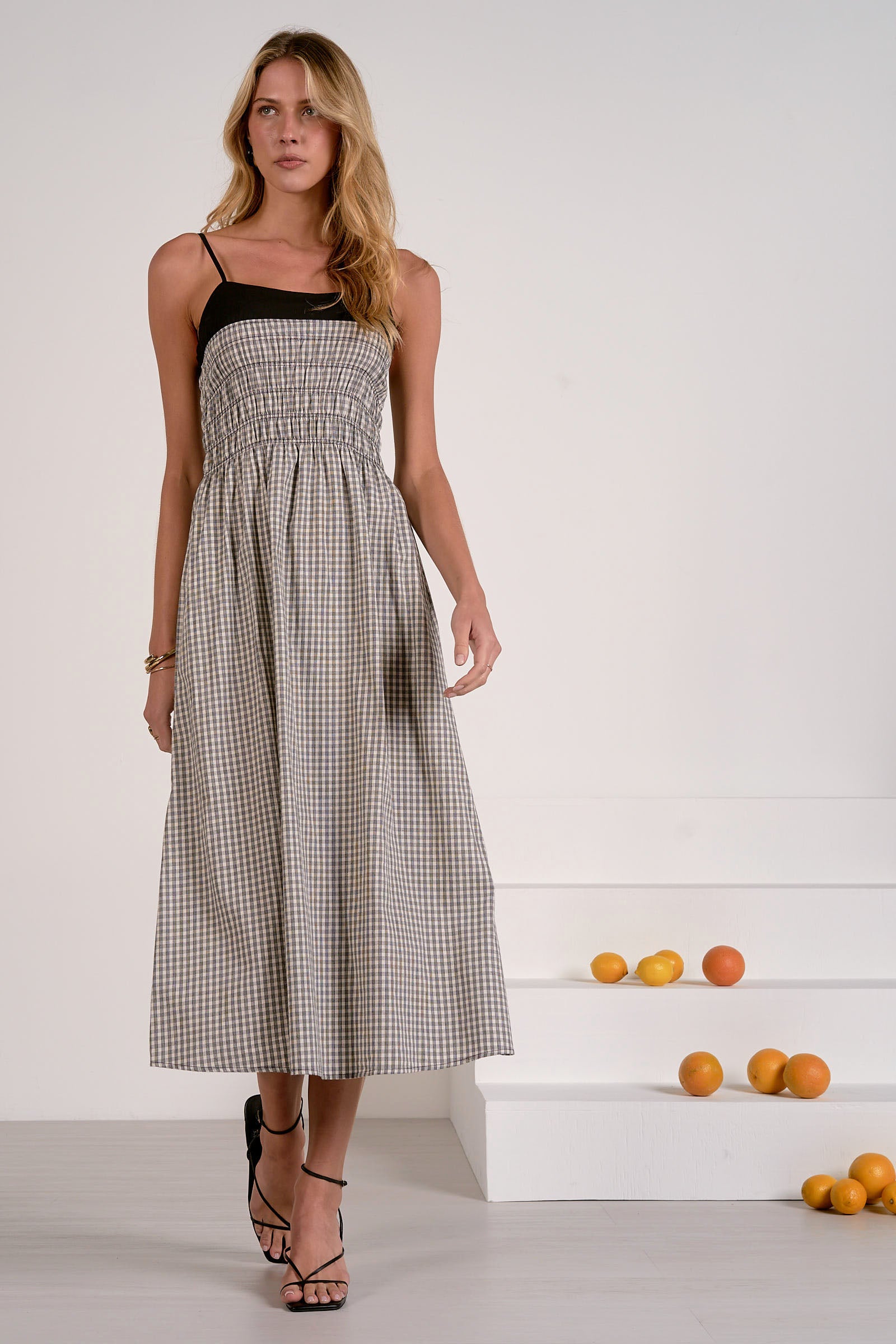 Woman wearing a black and white checkered dress with a plain background