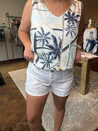 Person wearing a patterned shirt and white shorts in an indoor setting