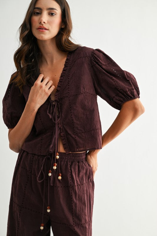 Model wearing brown embroidered puff sleeve tie-front top, front view with puff sleeves