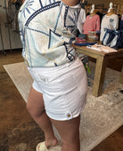 Person wearing a white outfit with blue patterns in a store setting