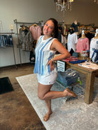 Woman wearing a crocheted sleeveless top. Blue and light green stripes on the tank