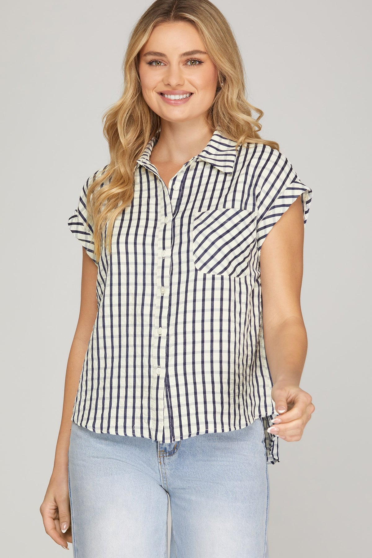 Woman wearing a black and white striped shirt with short sleeves on a gray background