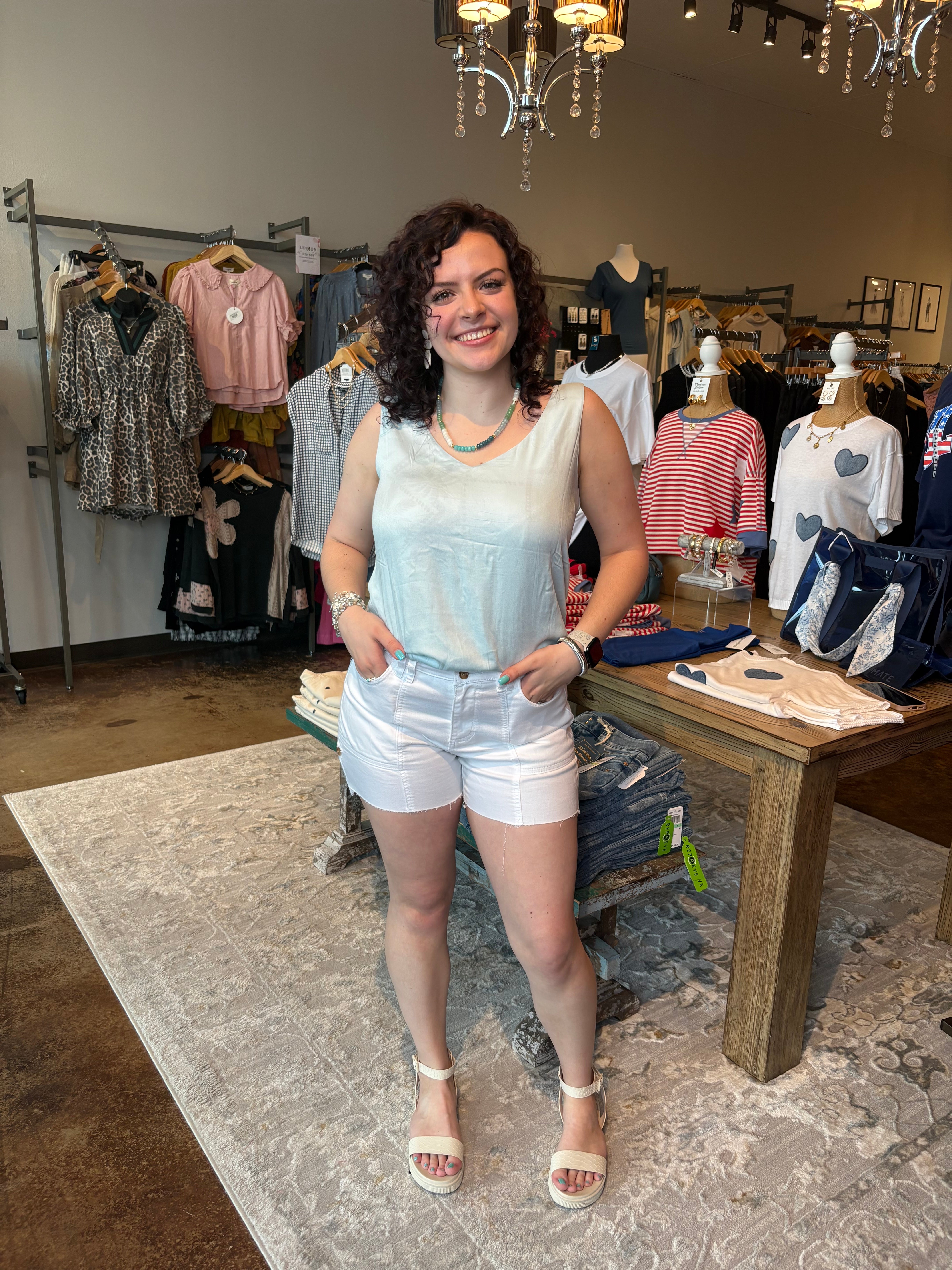 Woman wearing a sleeveless top with a palm tree pattern in a clothing store