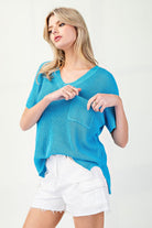 Woman wearing a blue sweater and white shorts on a white background