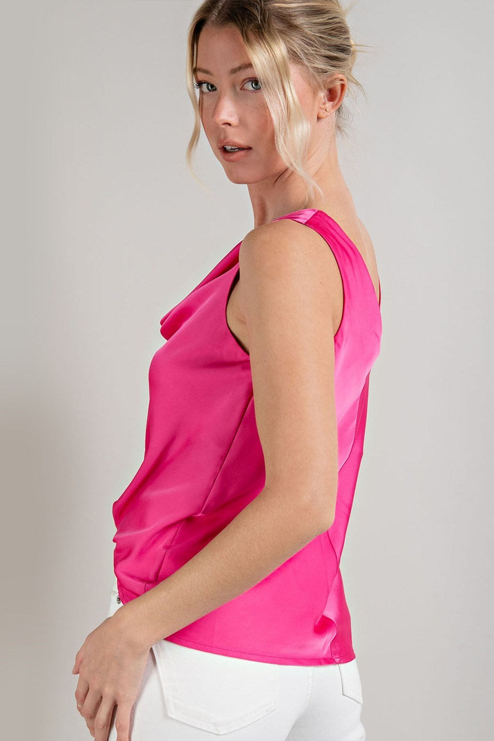 Woman wearing a bright pink sleeveless top against a plain background