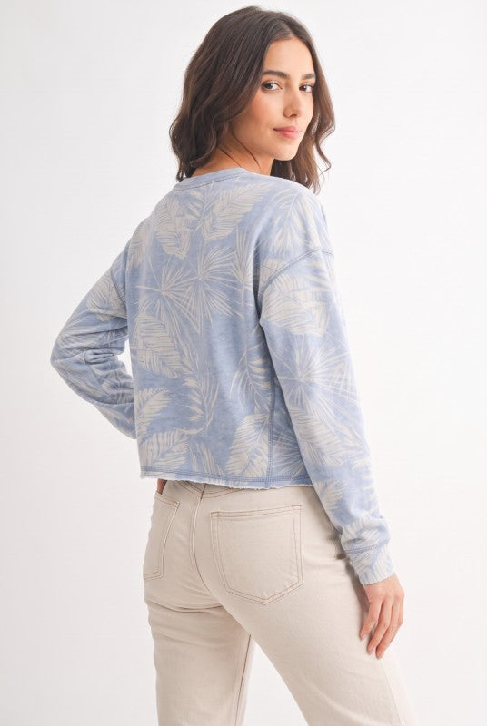 Model wearing dusty blue tropical print French terry crewneck sweatshirt, back view