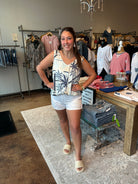 Woman wearing a sleeveless top with a palm tree pattern in a clothing store