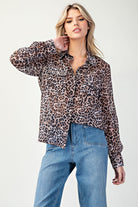 Woman wearing a leopard print shirt and blue jeans on a white background