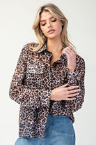 Woman wearing a leopard print shirt and blue jeans on a white background