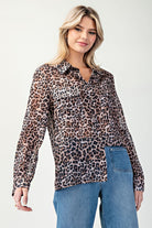 Woman wearing a leopard print blouse and blue jeans on a white background