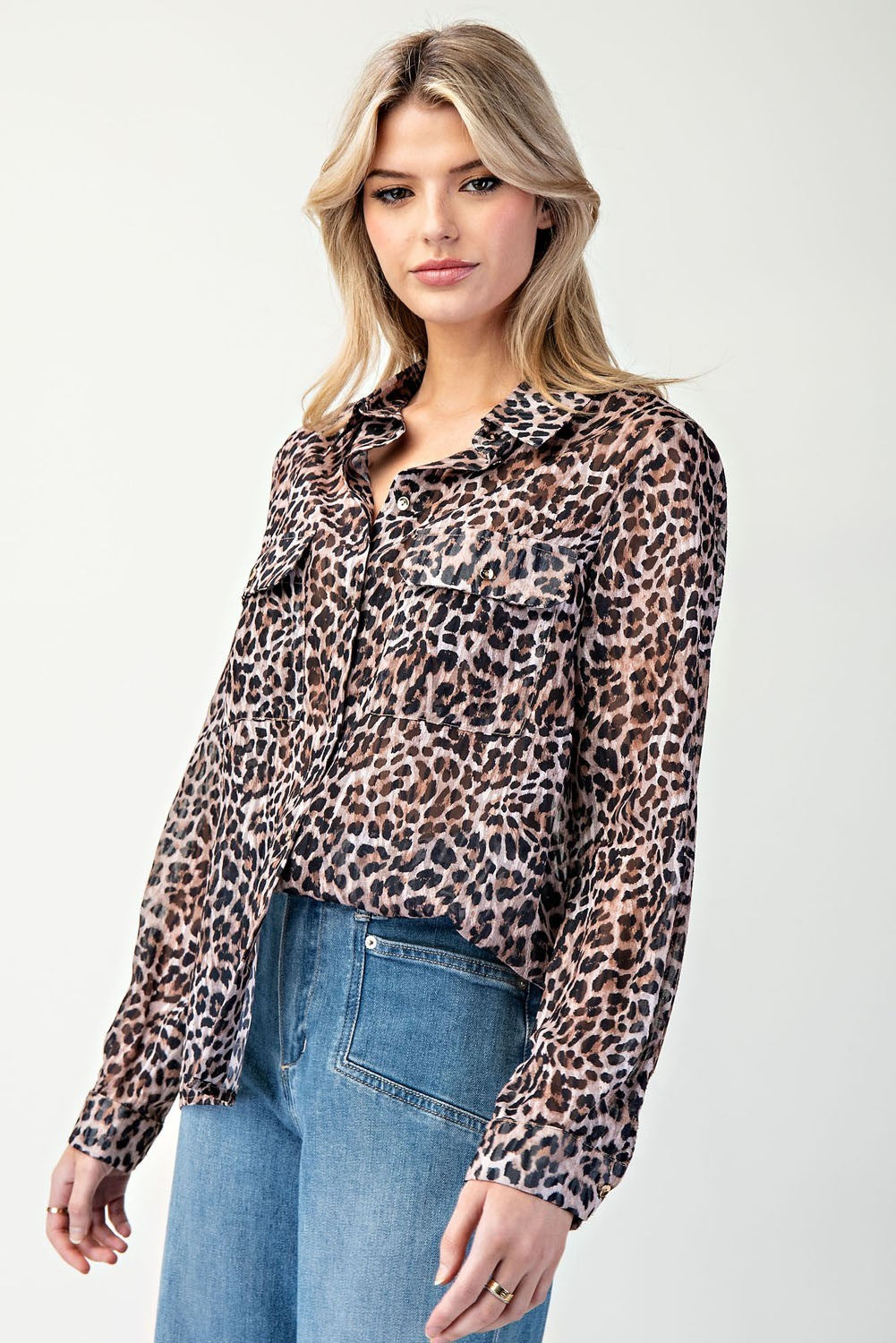 Woman wearing a leopard print shirt and jeans on a white background