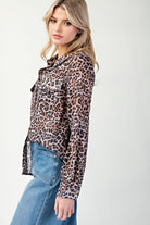 Woman wearing a leopard print shirt and blue jeans on a white background