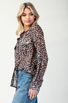 Woman wearing a leopard print shirt and blue jeans on a white background