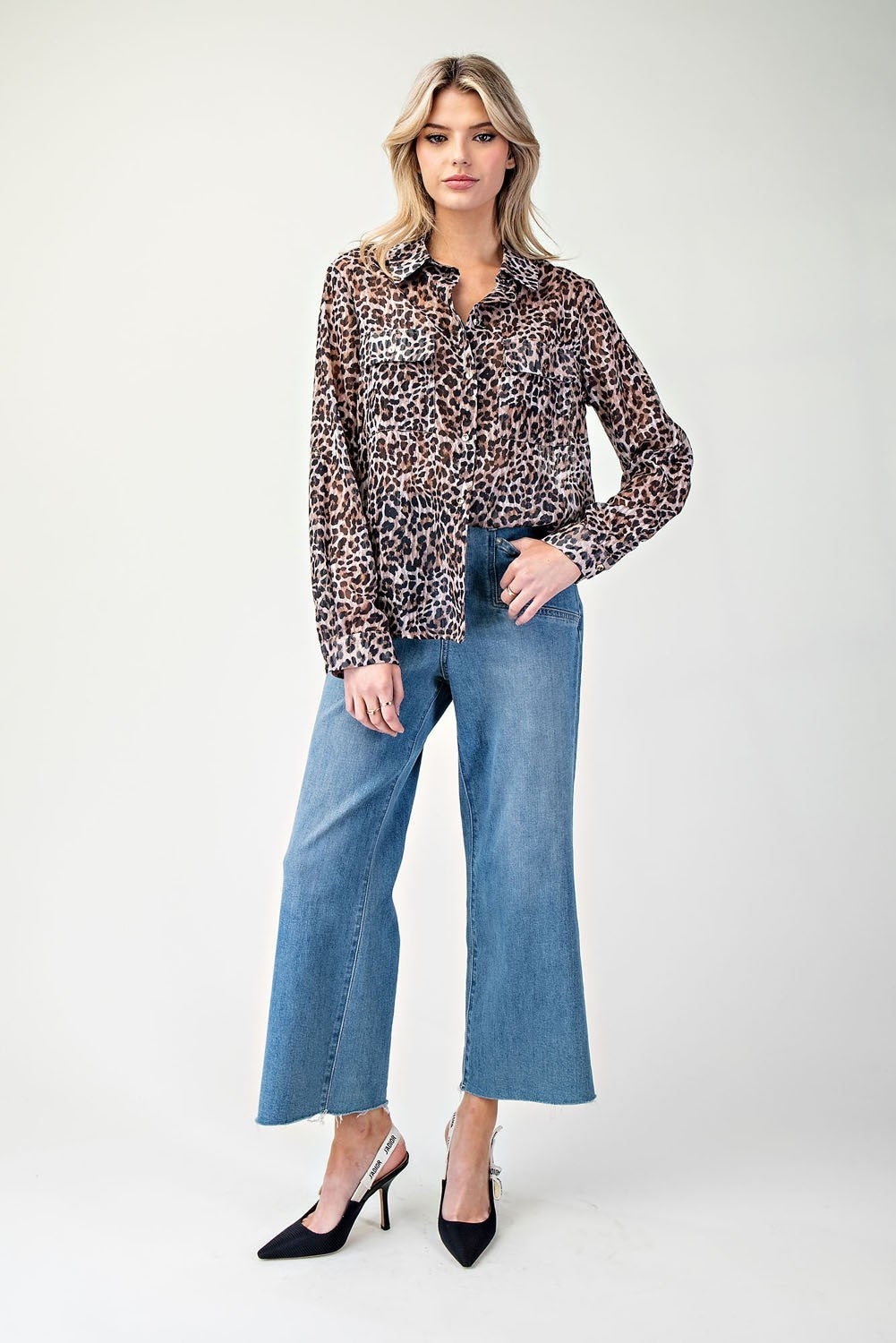Woman wearing a leopard print shirt and blue jeans on a white background