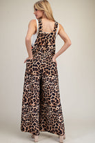 Woman wearing a leopard print jumpsuit on a plain background