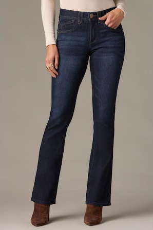 Person wearing dark blue jeans on a neutral background