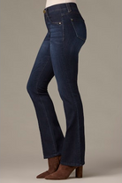 Dark blue jeans worn by a person on a neutral background