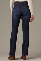 Dark blue jeans worn by a person on a neutral background