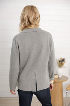 Person wearing a gray cardigan in an indoor setting