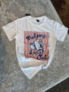 A white short-sleeve graphic T-shirt laid flat on a textured gray surface. The shirt features a red and white vertical stripe graphic with blue text reading 'Majiang Social Club' and a blue book illustration.