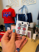 Hand holding a card with earrings in a store setting