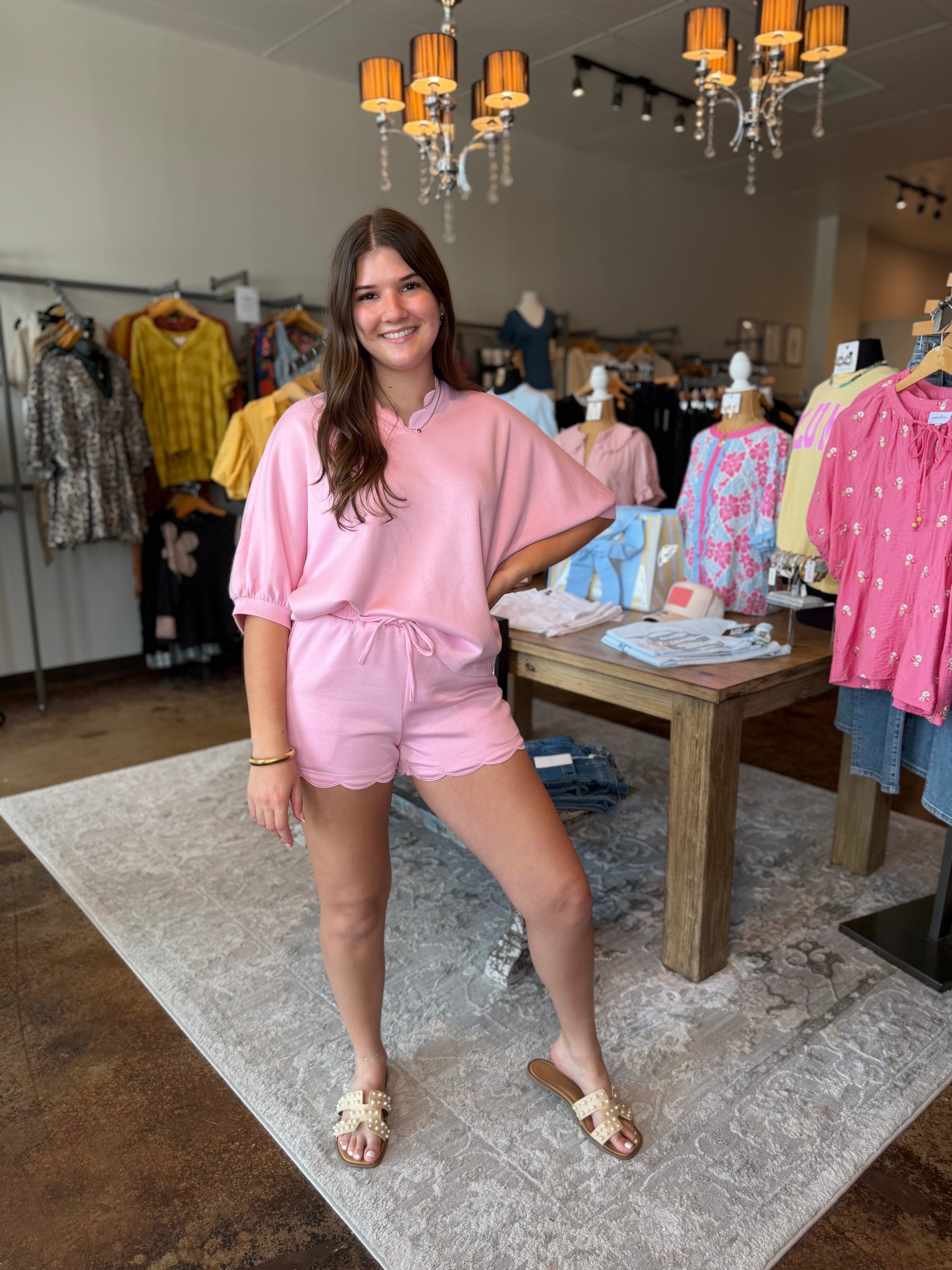Woman in a pink outfit standing in a clothing store.