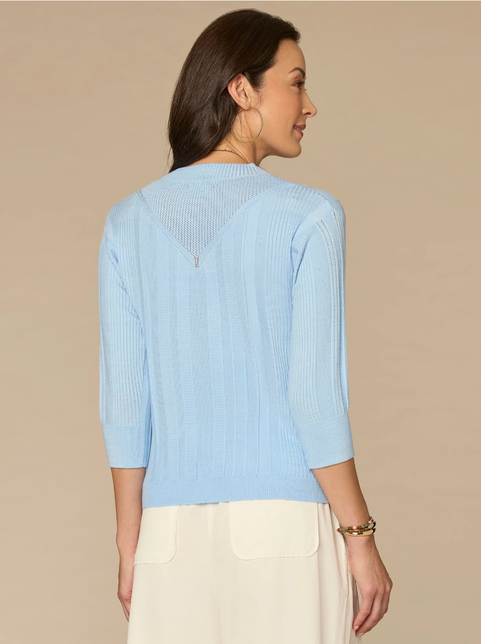 Woman wearing a light blue top with a beige background