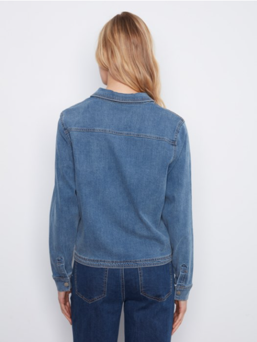 A woman viewed from the back wearing a medium-wash blue denim jacket over a dark blue denim shirt, set against a plain white studio background.