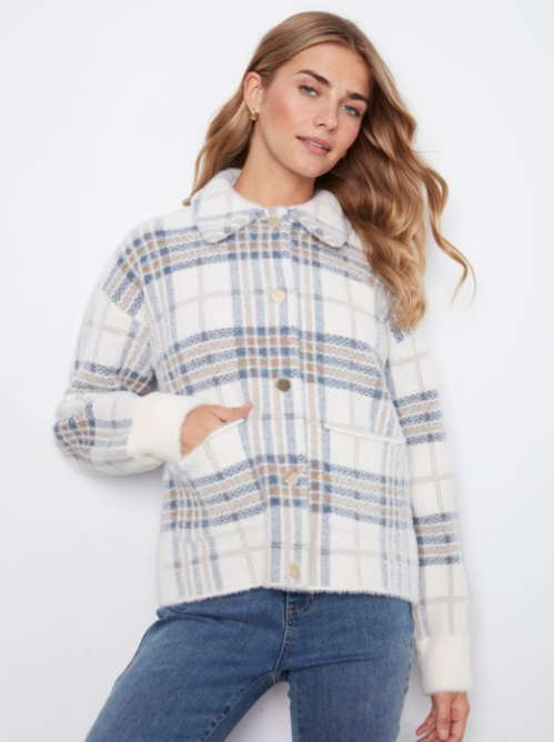A woman wearing a white plaid button-up jacket with blue and beige stripes, paired with blue jeans, against a plain white background.