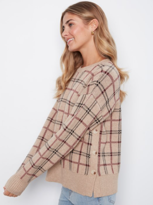 A woman wearing a beige knit cardigan with a brown and black plaid pattern, shown from a side profile against a plain white background.