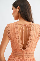 Model wearing orange lace boho midi dress, side view