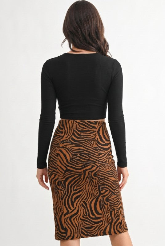 A woman shown from the back wearing a black long-sleeve crop top and a brown and black zebra-print pencil skirt, against a plain white background.