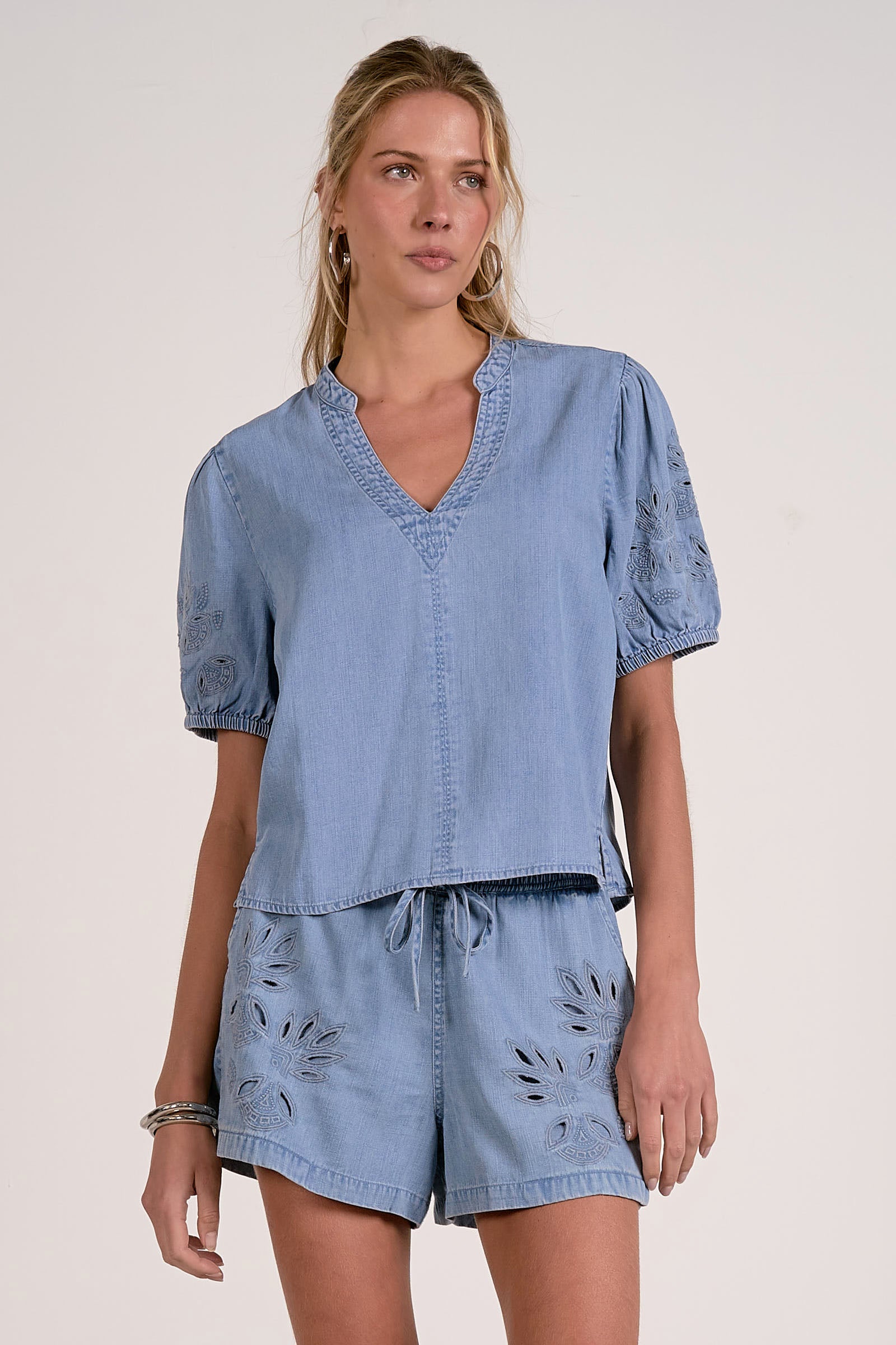 Woman wearing a blue outfit with puff sleeves on a white background