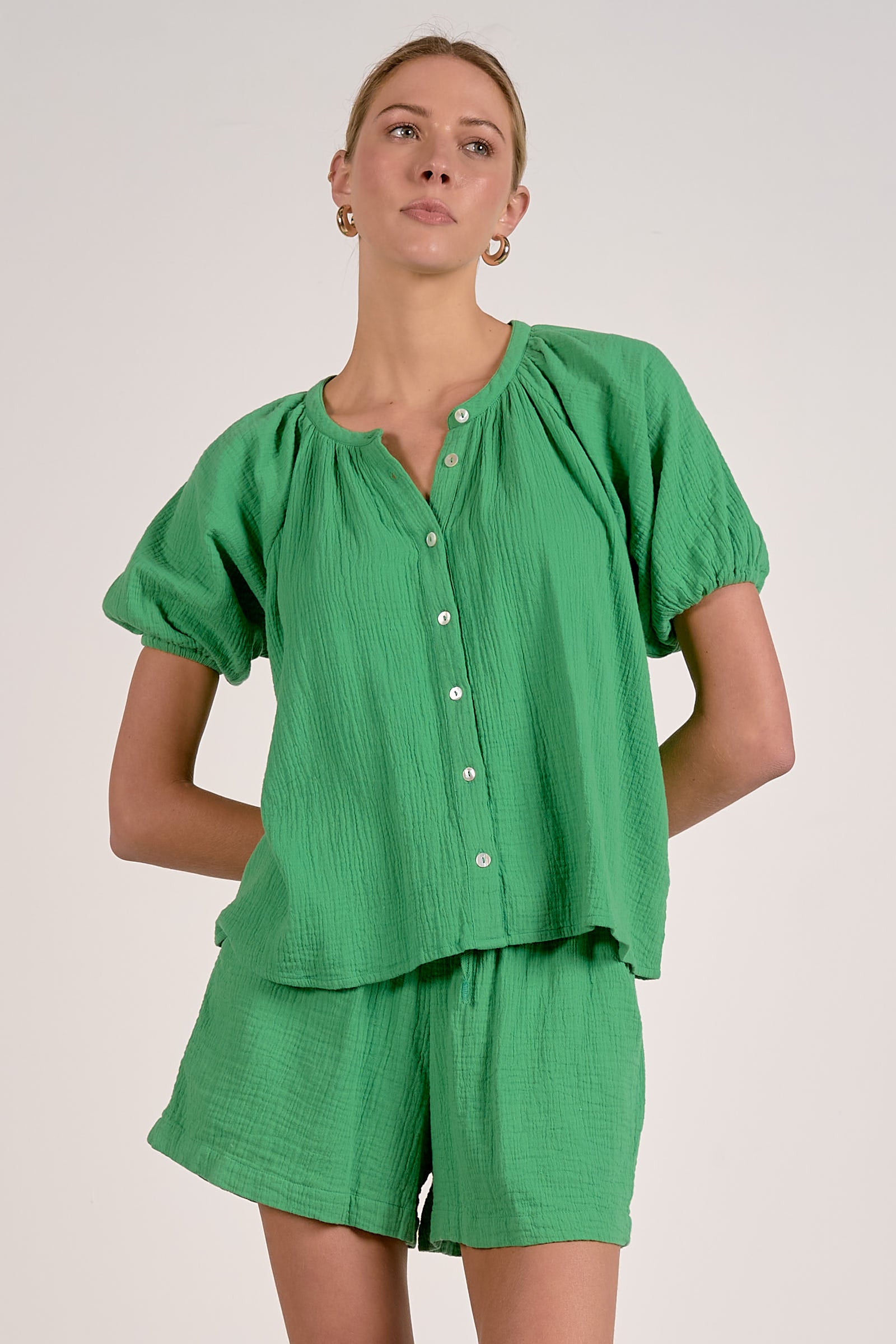 Woman wearing a green outfit with a plain background